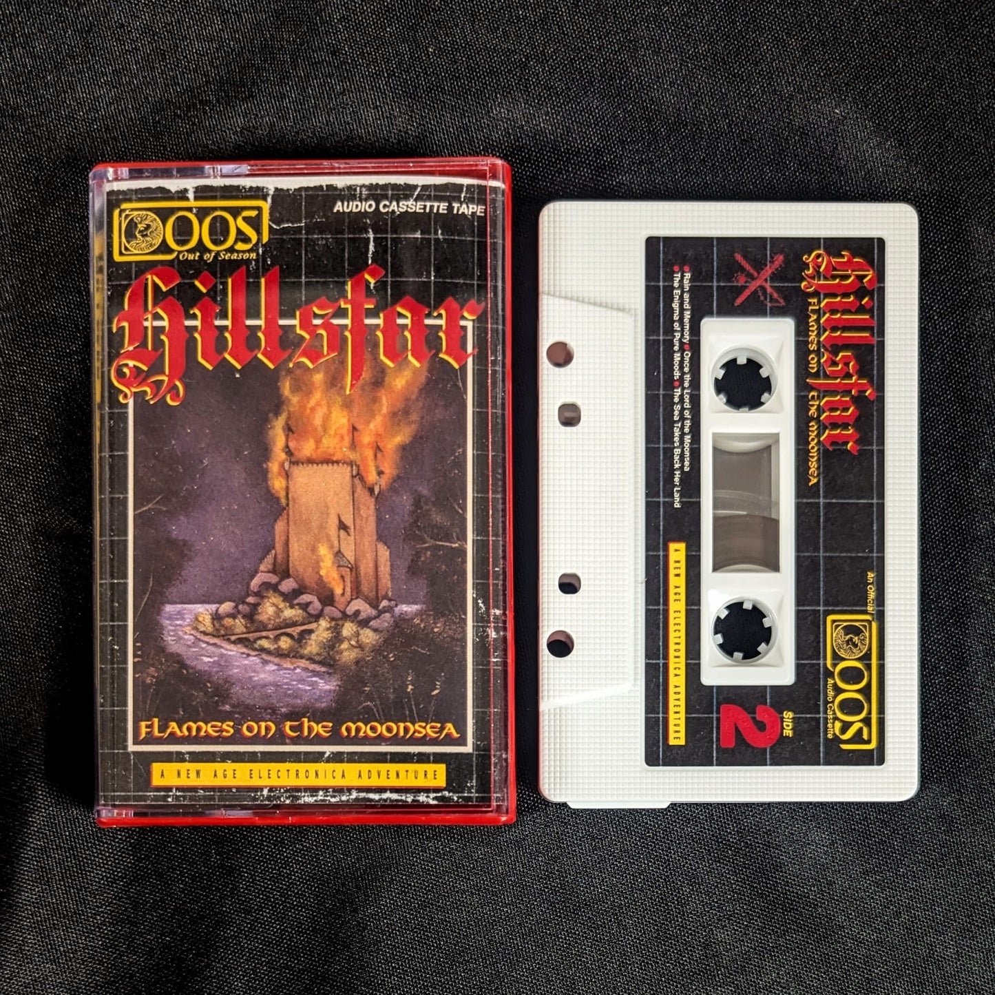 HILLSFAR "Flames on the Moonsea" cassette tape, white shell with printed sticker labels, Norelco case, and printed jcard