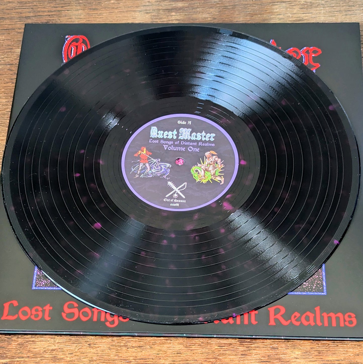 Vinyl record with a purple label on a matching black sleeve, on a wooden surface.