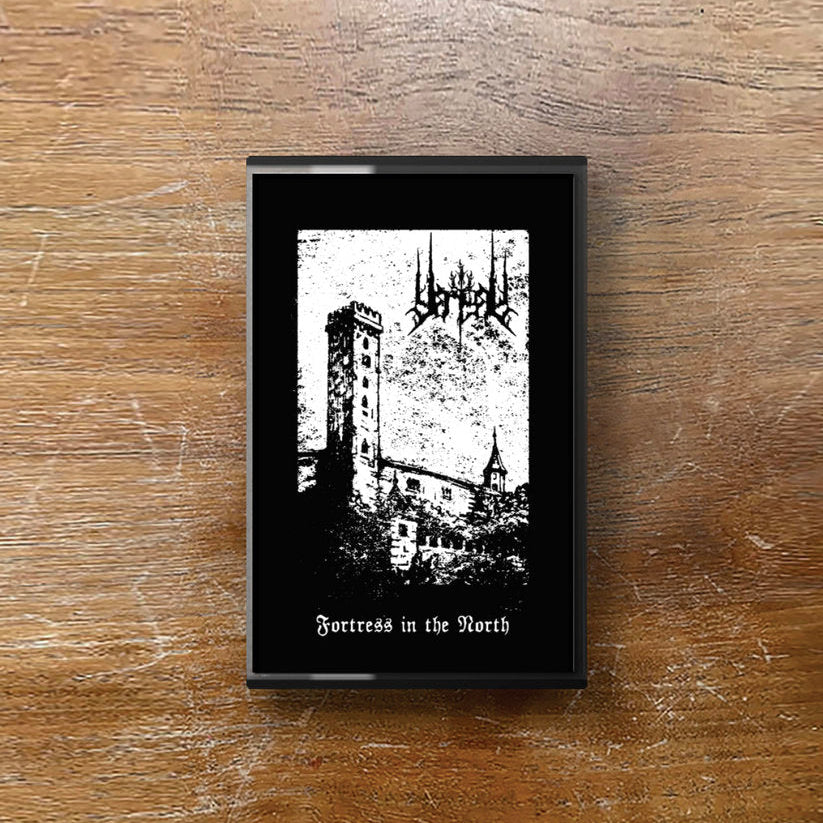 Framed black and white print of a castle on a wooden surface