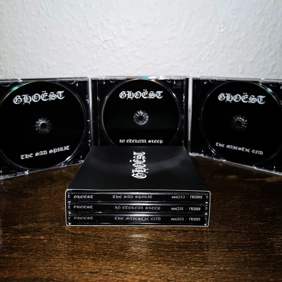 Collection of 'Gloest' music albums on a wooden surface with a white wall background.