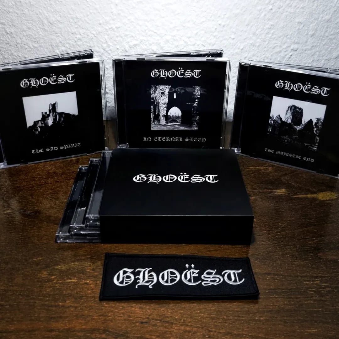 Collection of 'GHOEST' music albums and merchandise on a wooden surface.