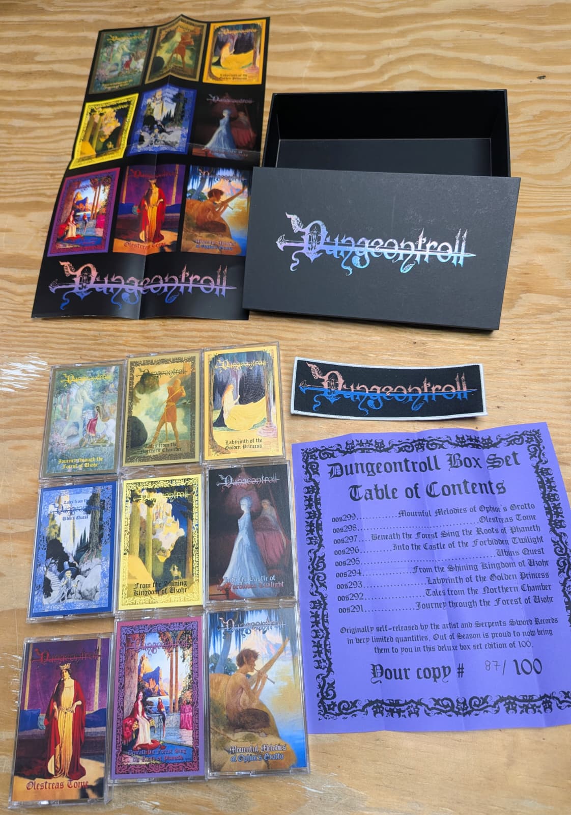 Collection of 'Dungeontroll' tapes and packaging on a wooden surface