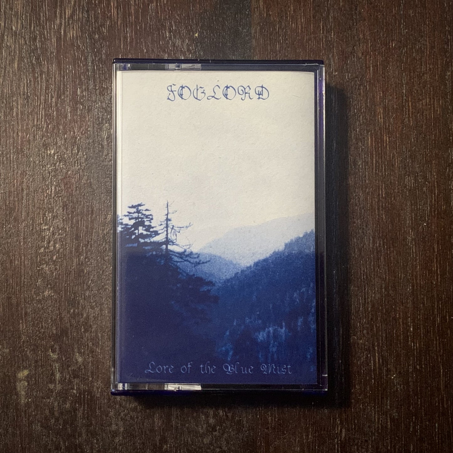 Cassette tape with a mountain landscape design on a wooden surface