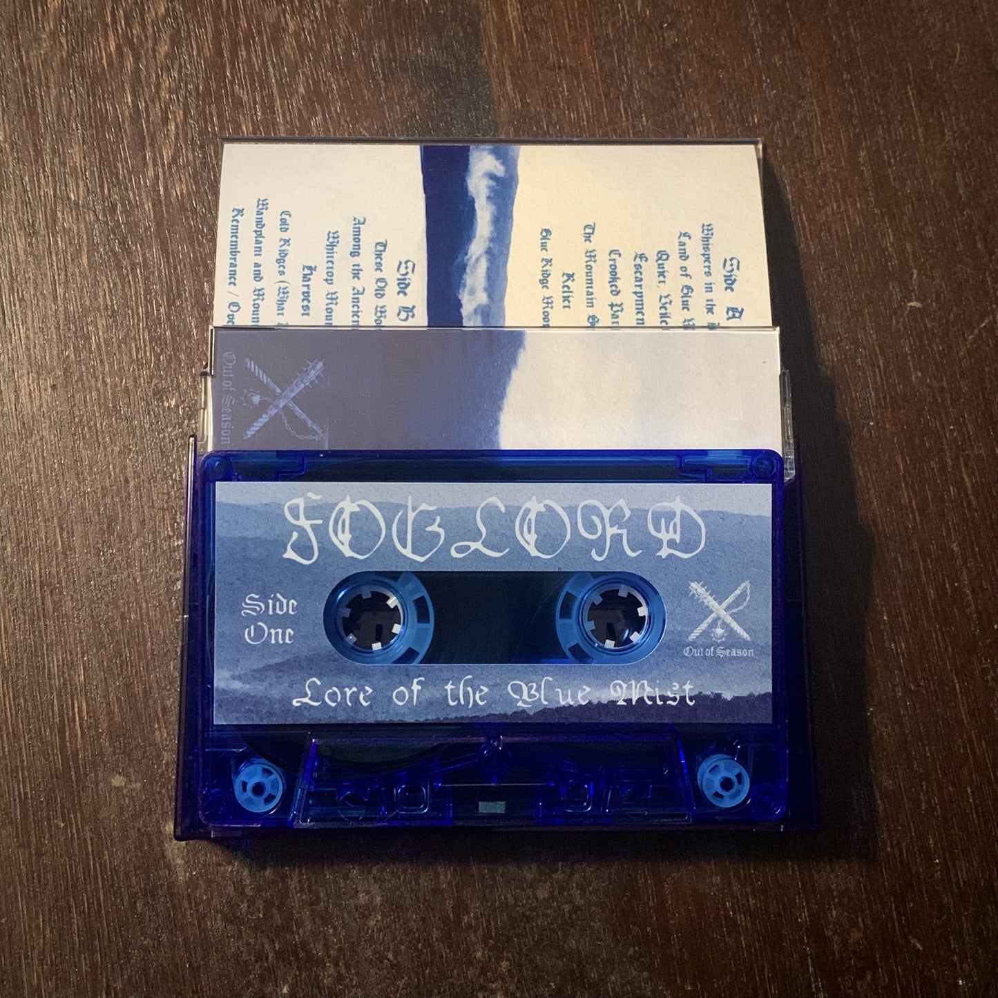 Blue cassette tape with white text on a wooden surface