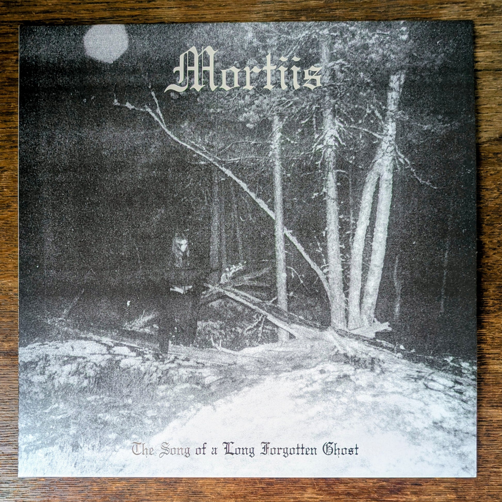 Album cover with a person in a forest, featuring the title 'Mortiis' and 'The Song of a Long Forgotten Ghost'.