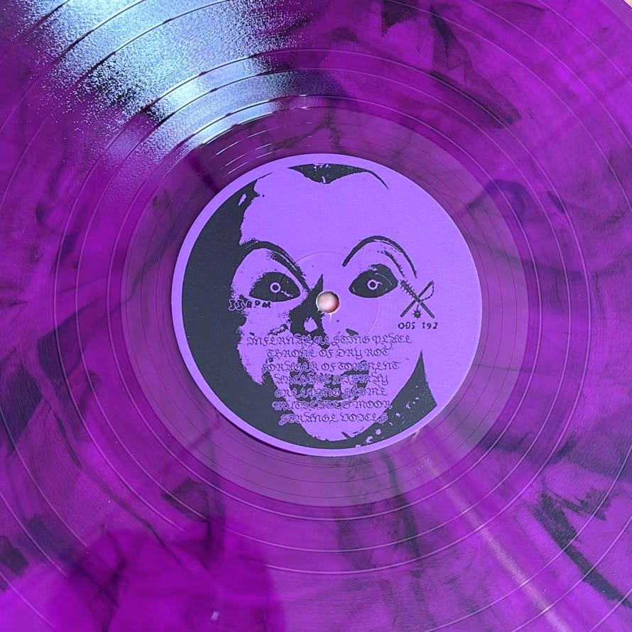 Purple vinyl record with a face design on the label