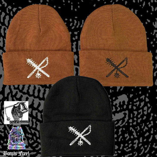 Three beanies in brown, black, and black with embroidered designs on a patterned background.