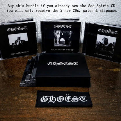 GHOEST music bundle with CDs, patch, and slipcase on a wooden surface.