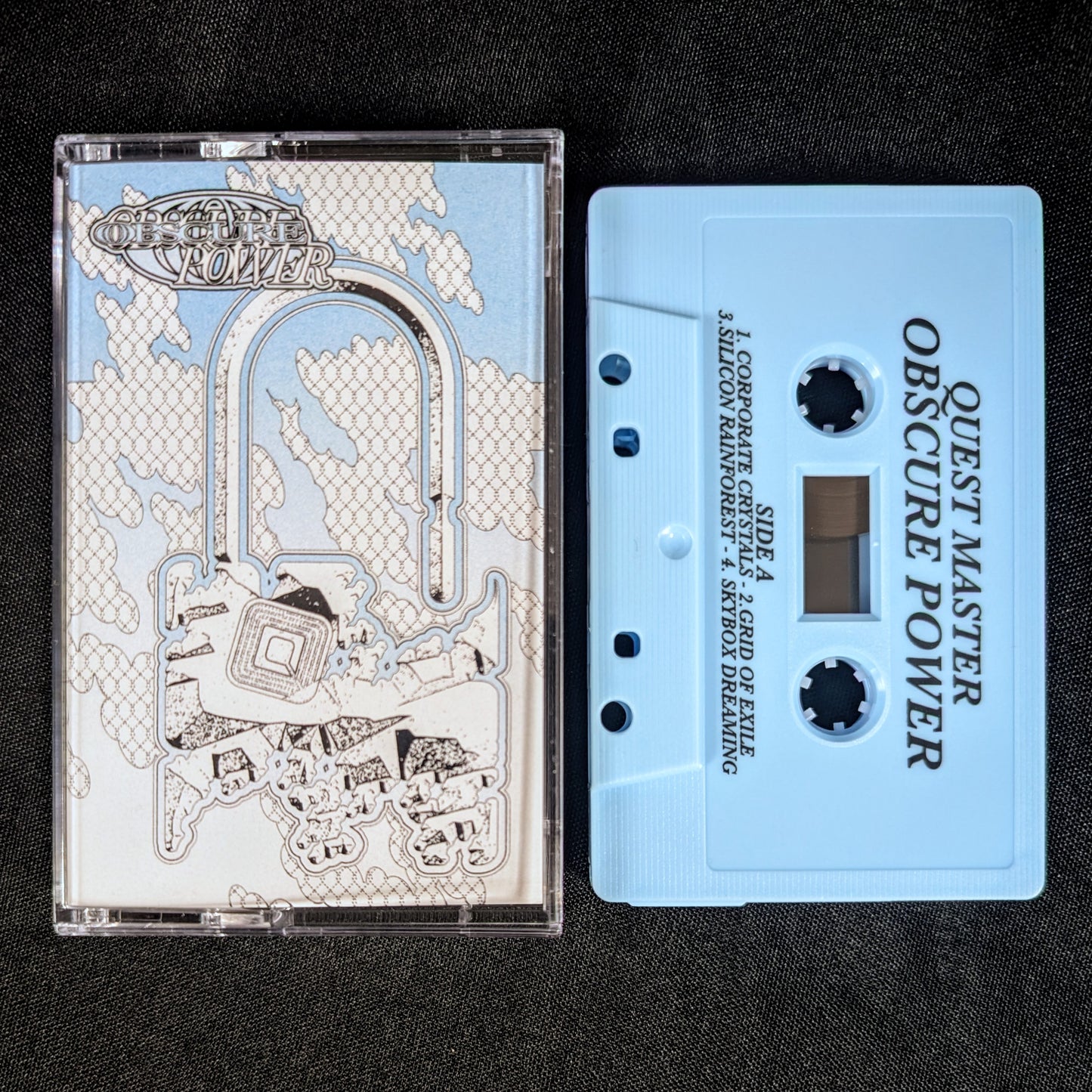 Cassette tape with 'Quest Master Obscure Power' design on a black background