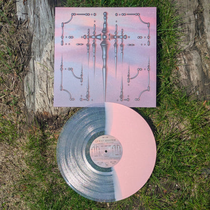 Vinyl record with a pink and clear design on a grassy surface