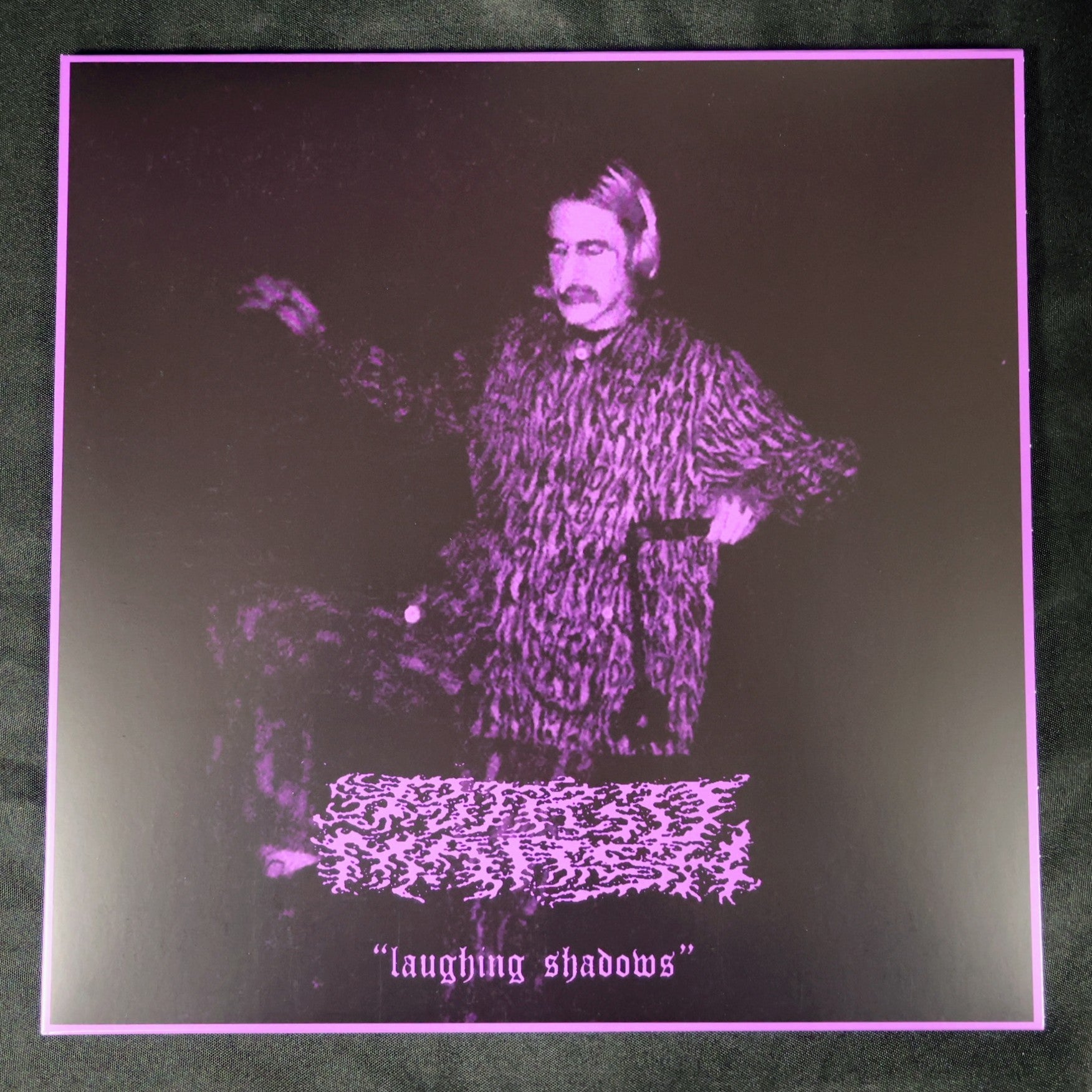 Album cover with a stylized illustration of a person and text 'laughing shadows' on a dark background.