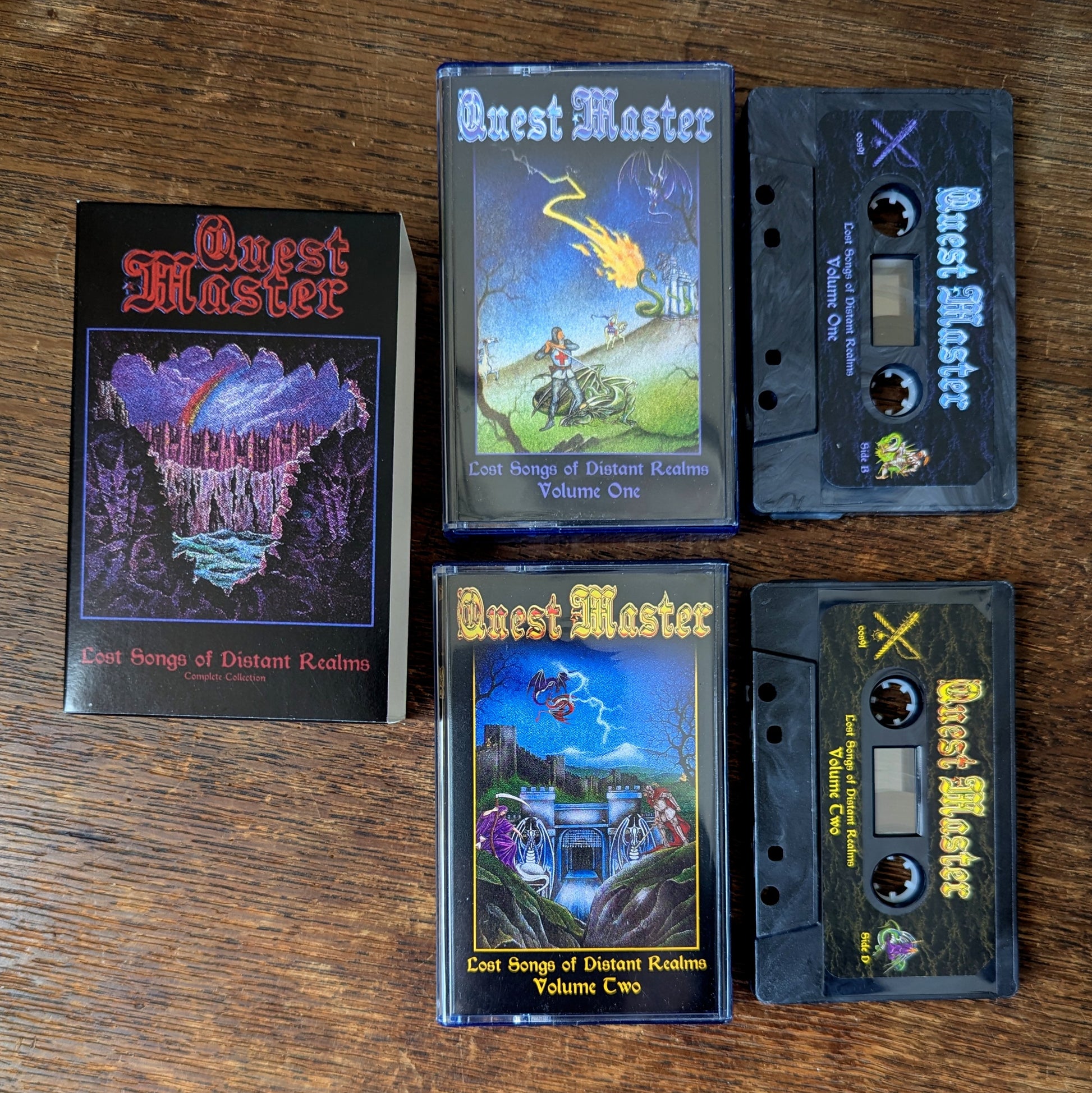 Two 'Quest Master' cassette tapes and their covers on a wooden surface