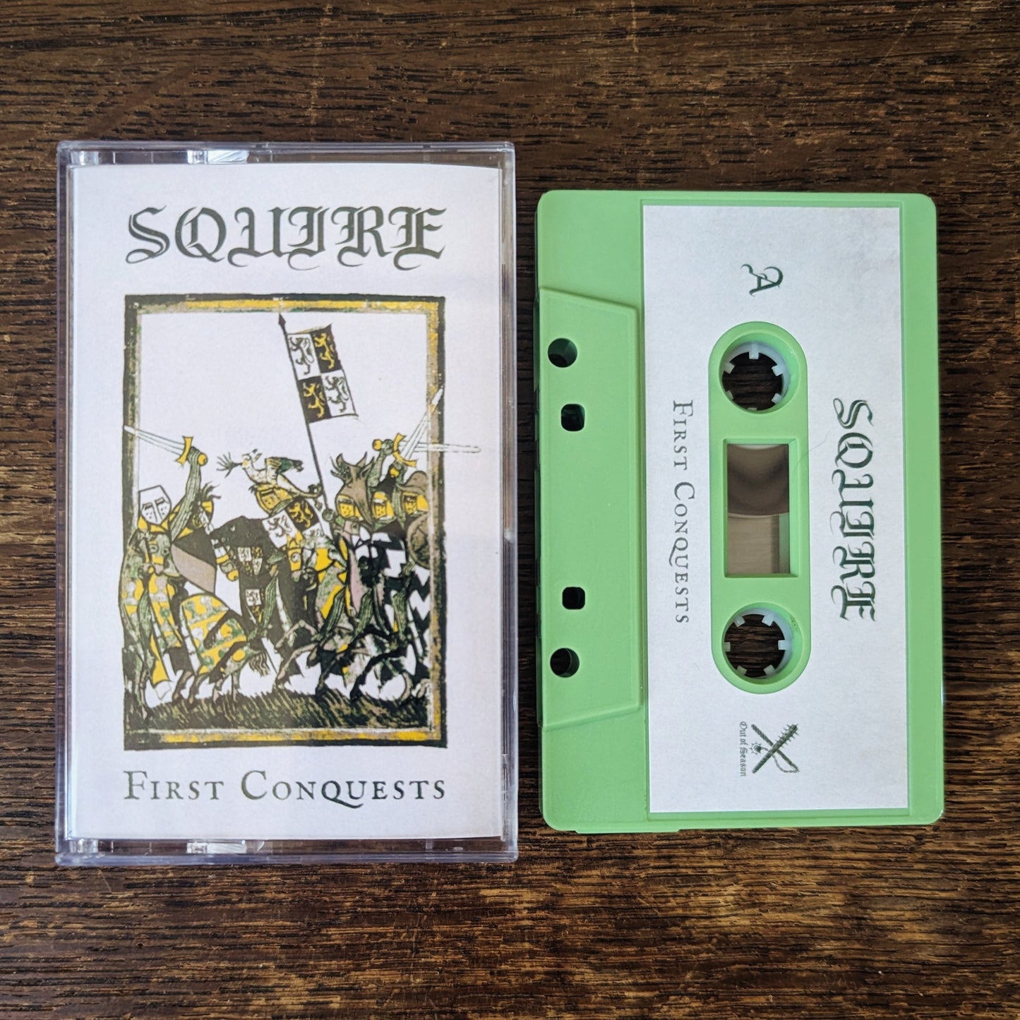 Squire 'First Conquests' cassette tape and cover on a wooden surface