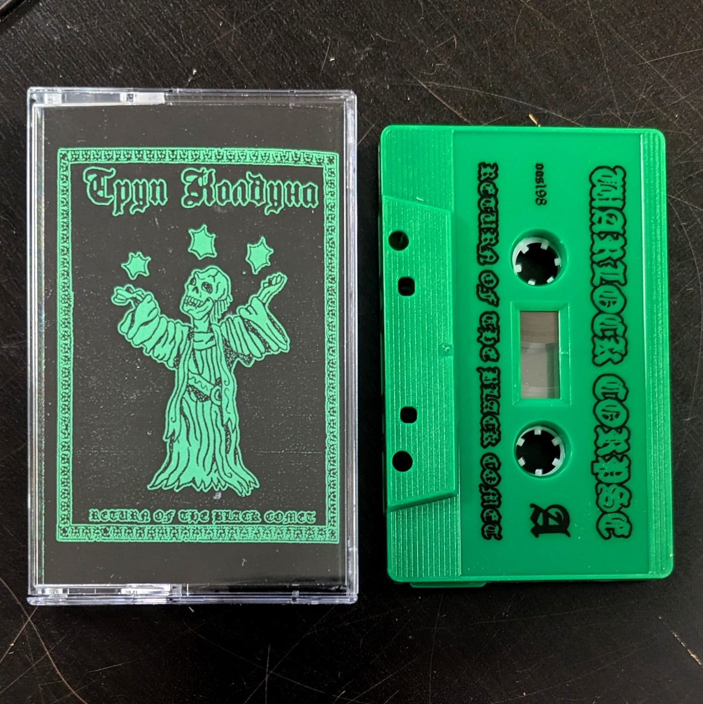 Green cassette tape with a clear cover on a dark surface