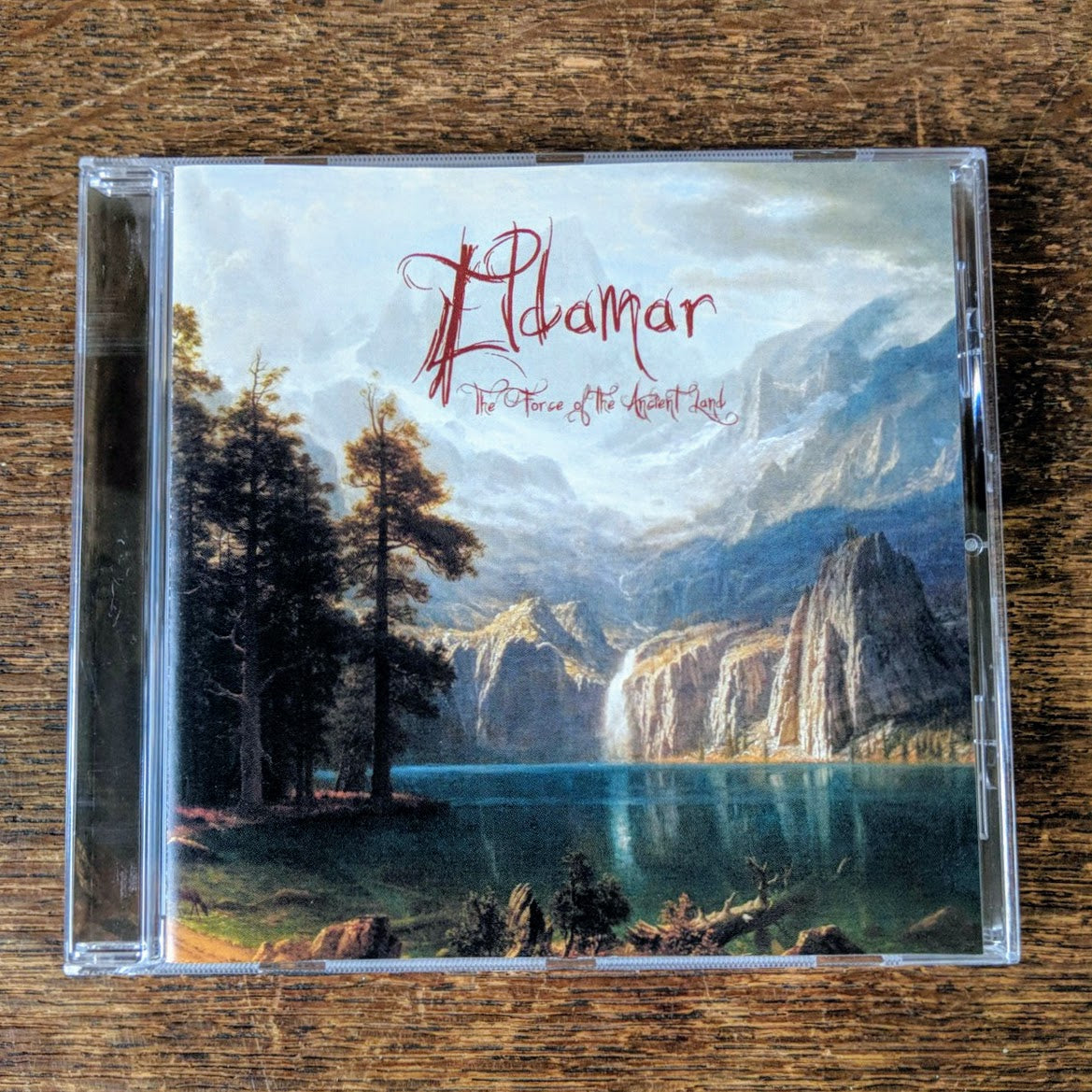 ELDAMAR "The Force of the Ancient Land" CD, jewel case, with cover art of mountains with a waterfall spilling into a blue lake, with trees along the shoreline